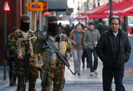 Belgian soldiers patrol in central Brussels as police searched the area during a continued high level of security following the recent deadly Paris attacks